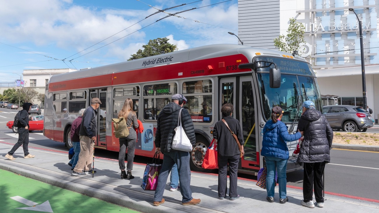 People boarding a bus from a bus boarding island adjacent to a bike lane