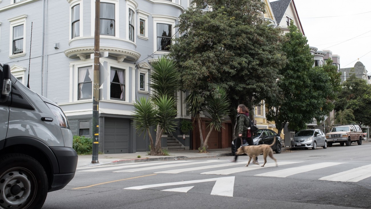 A woman crossing the street in a raised crosswalk