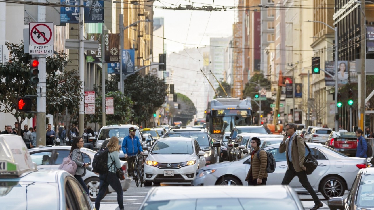 People walking and biking on a congested street downtown