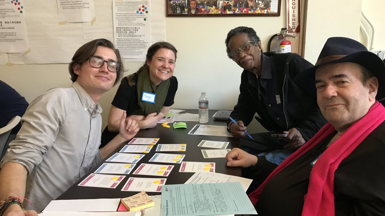 people sitting at a table playing a congestion pricing card game