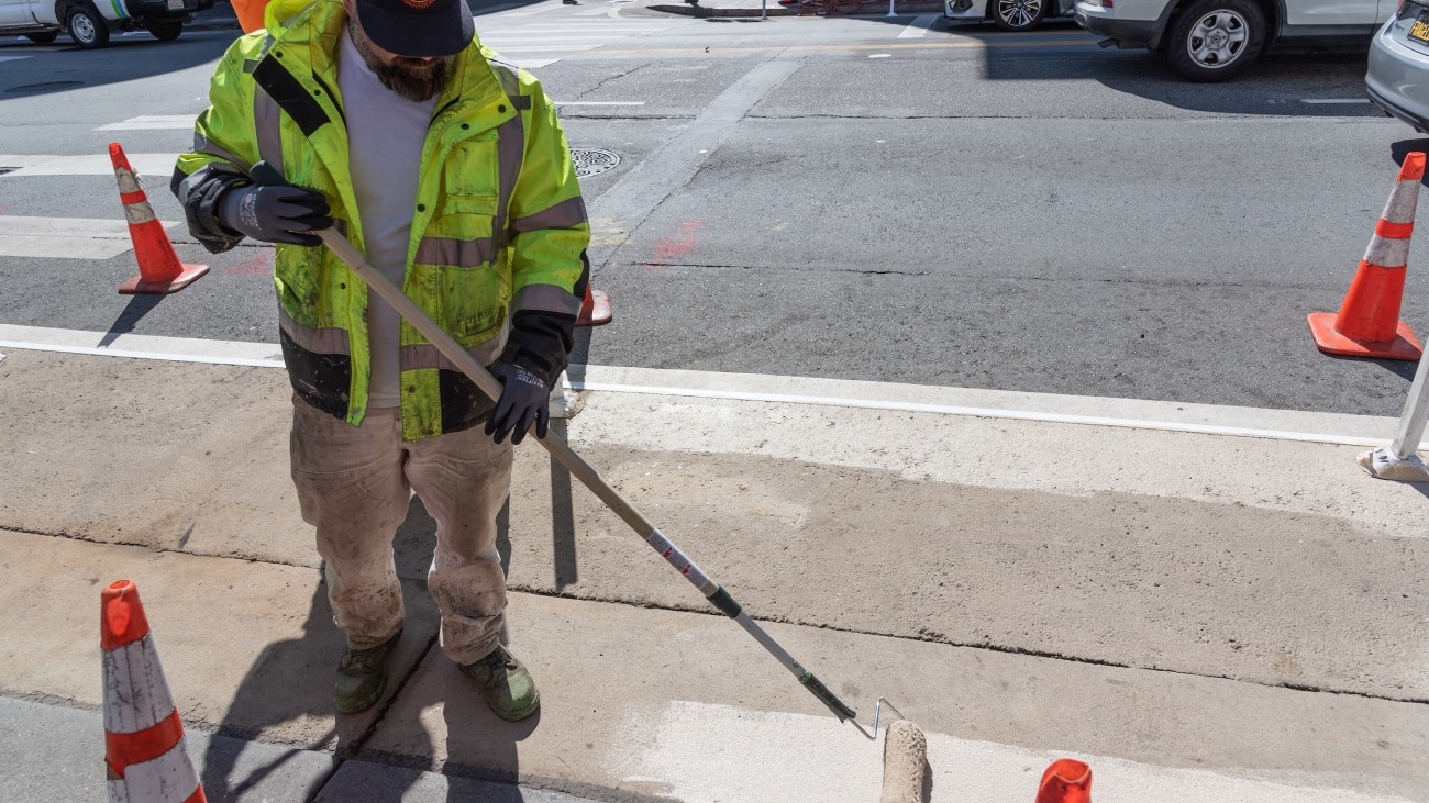 Person painting a pedestrian safety zone