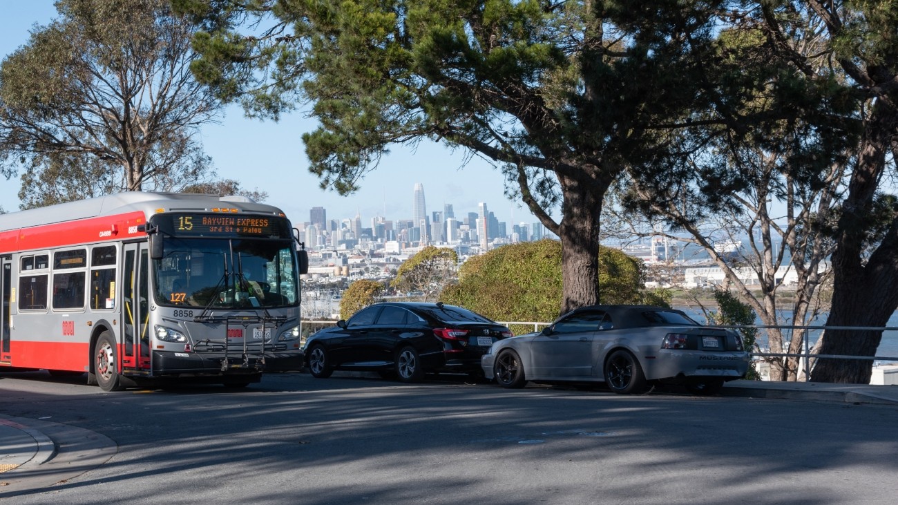 Muni bus drives past cityscape