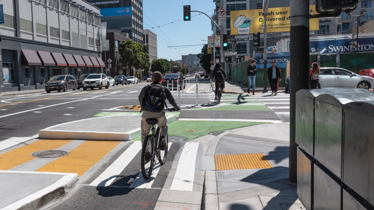 Cyclist riding through protected intersection at 5th and Howard Street