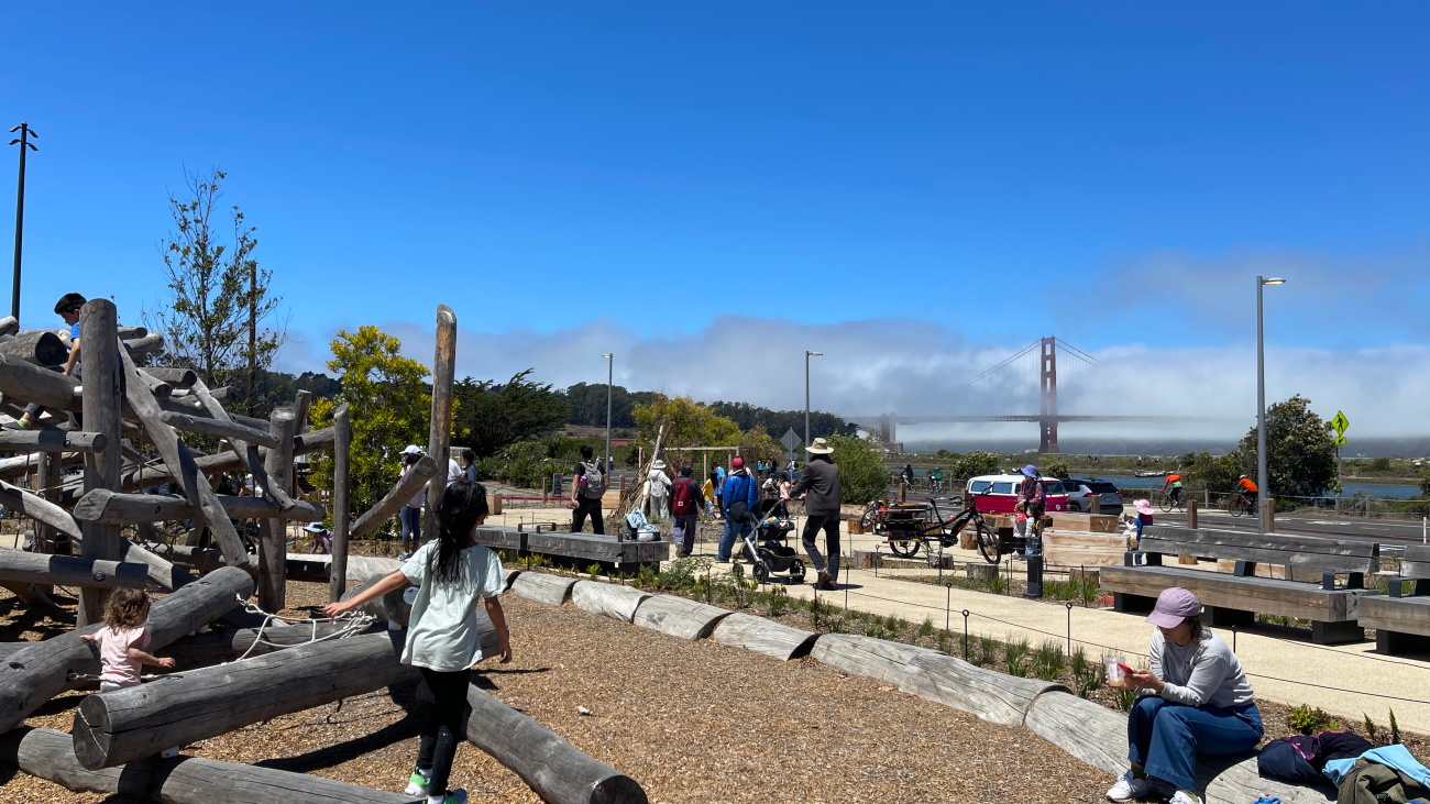 Children on play structure and people walking on path