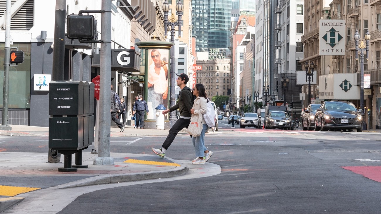 Two pedestrians approach a bulbout or sidewalk extension