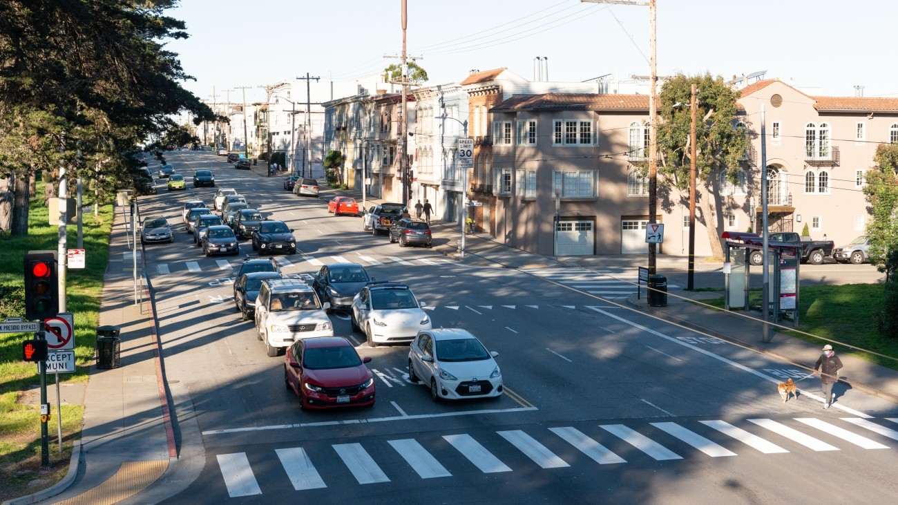 Vehicles stopped by traffic light on road along Fulton Street