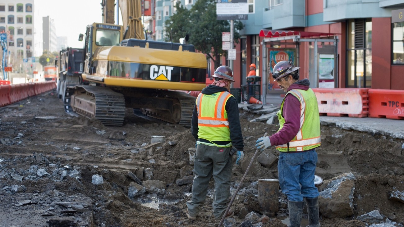 Workers standing in front of demolition debris