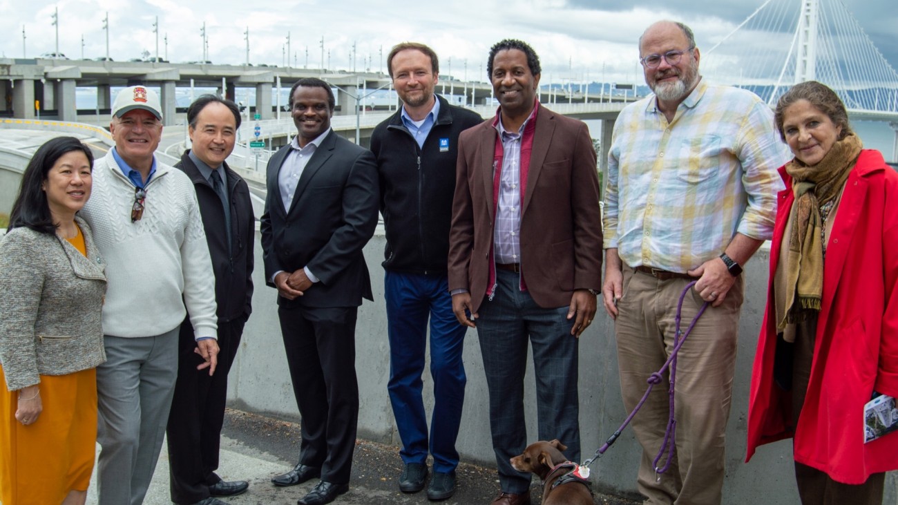 A group of people, including SFCTA Executive Director Tilly Chang and SFCTA Deputy Director for Capital Projects Carl Holmes, stand in front of the newly-finished Yerba Buena Island / I-80 Southgate Road and Interchange Project.