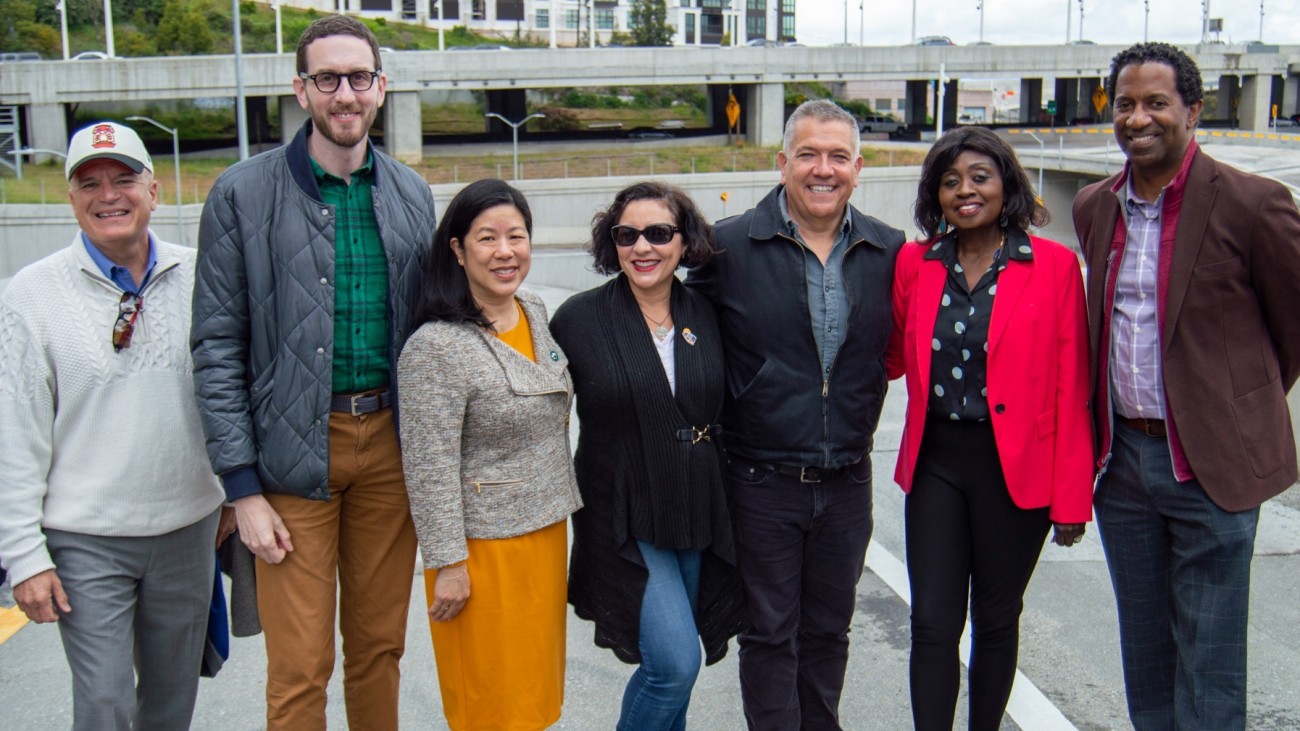 A group of people, including SFCTA Executive Director Tilly Chang and State Senator Scott Wiener, stand in front of the newly-finished Yerba Buena Island / I-80 Southgate Road and Interchange Project.