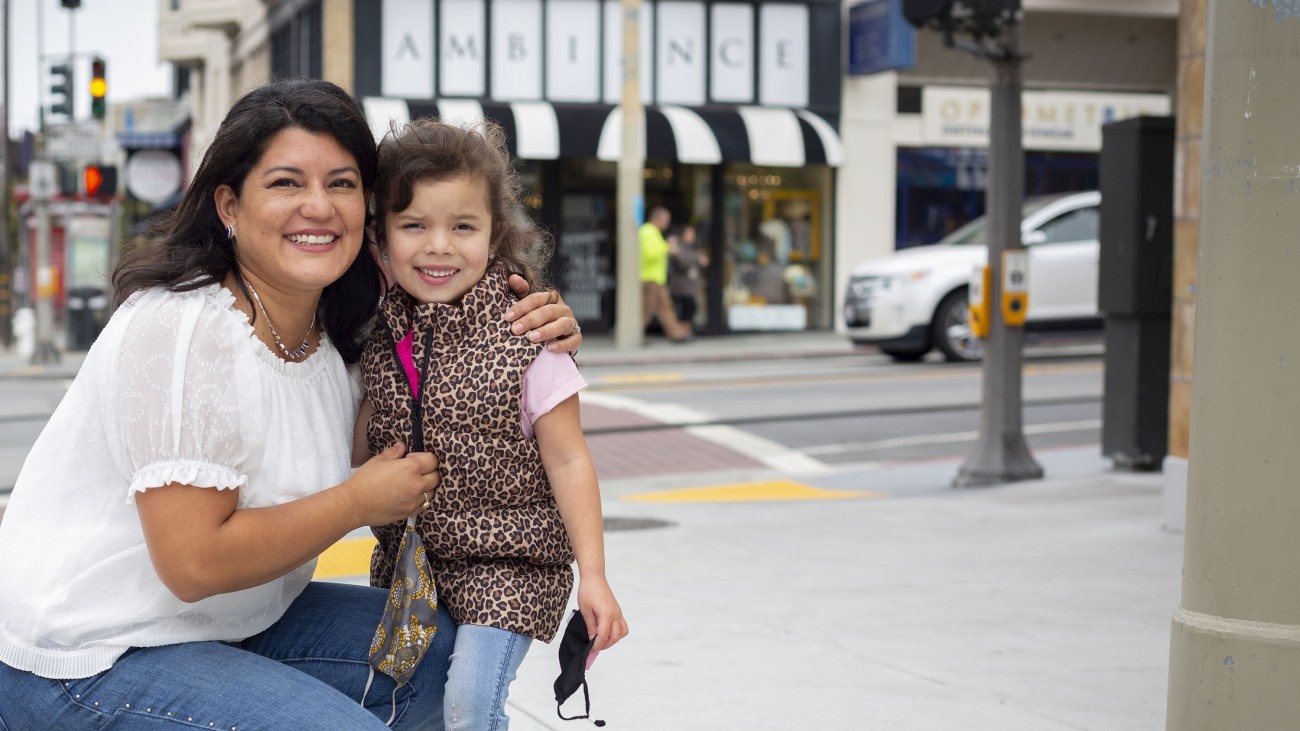 A woman with a child on the sidewalk