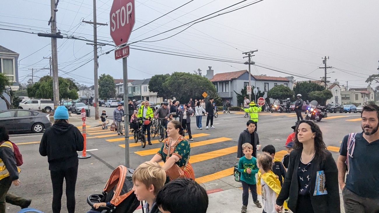 Students and adults walking as a group to get to school in celebration of Walk and Roll to School Day