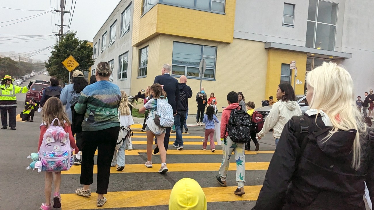 Parents and students in a crosswalk on their way to school