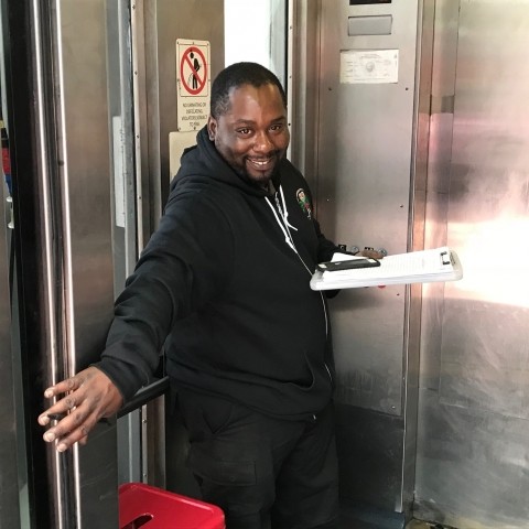 An elevator attendant in an elevator opening the door