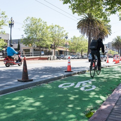 Bicyclist on green painted bicycle path in Upper Market Street