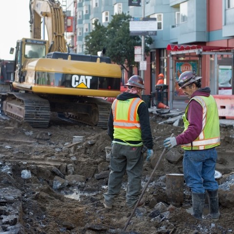 Workers standing in front of demolition debris