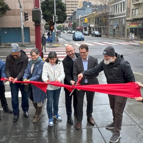 Staff cutting a ribbon for the completion of the Safer Taylor Street project